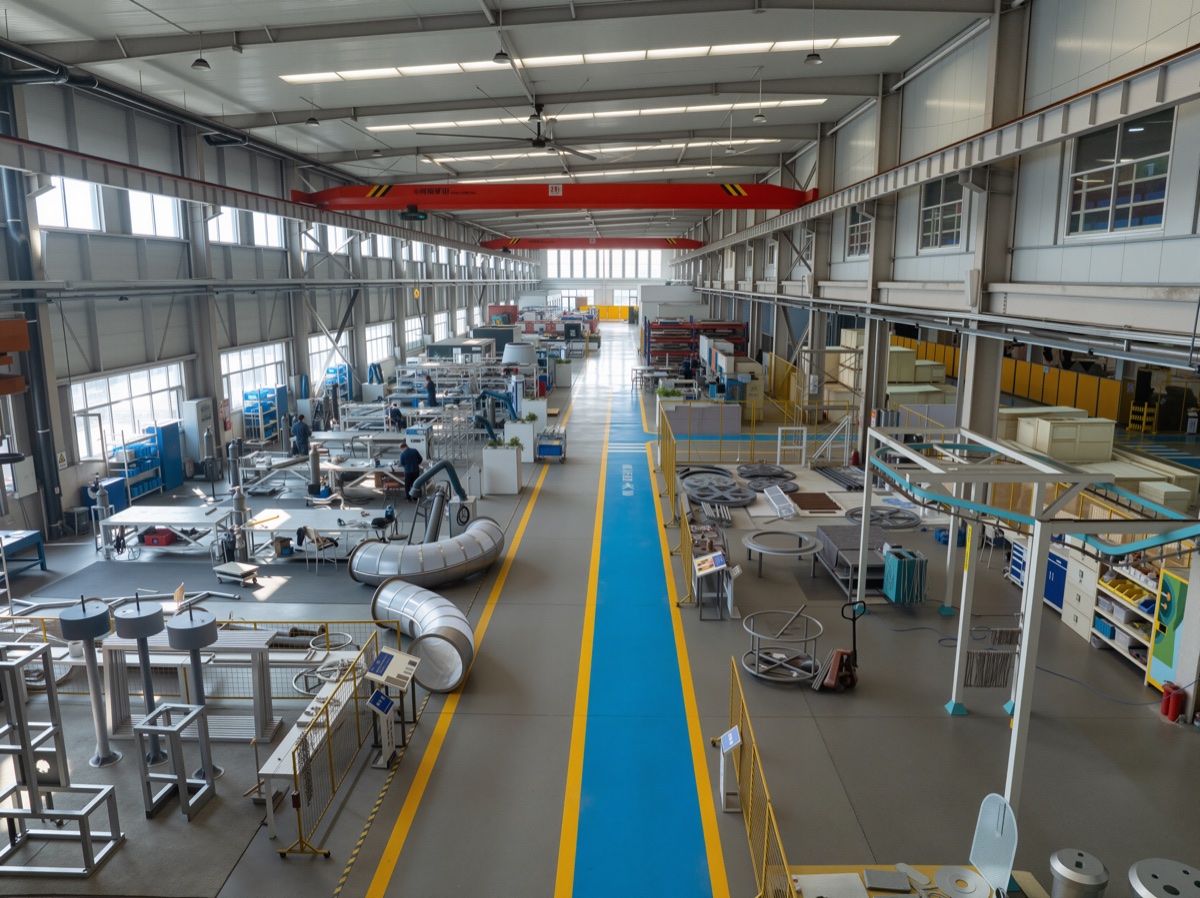 Clean DEEPBLUE workshop aisle with large-format exhibit manufacturing areas and overhead crane equipment Clean DEEPBLUE workshop aisle with large-format exhibit manufacturing areas and overhead crane equipment