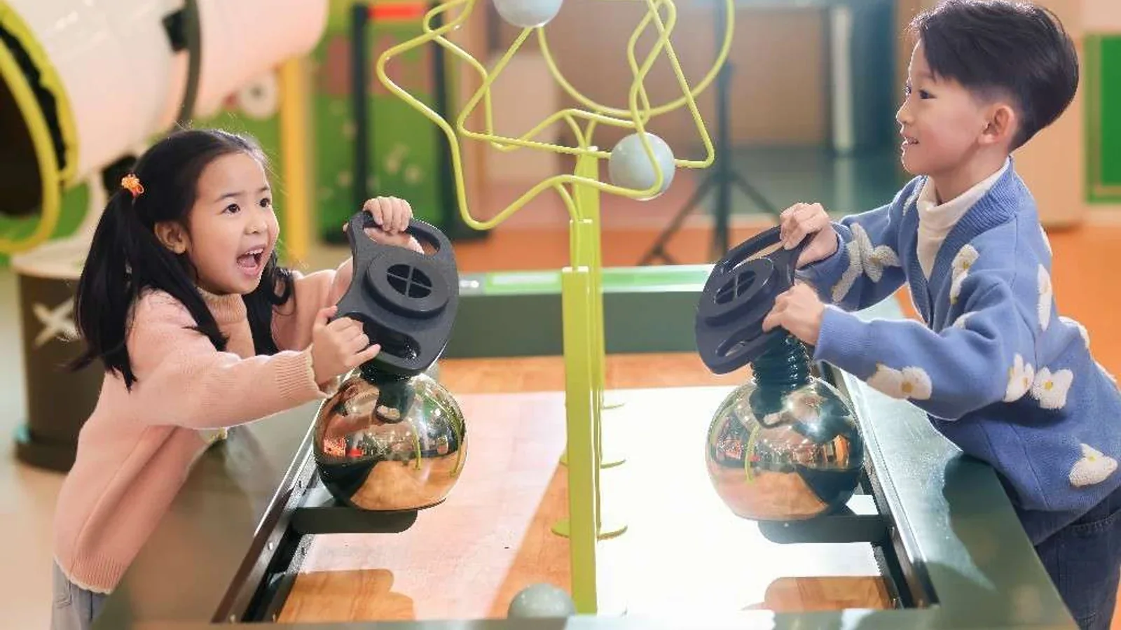 Dos niños operando juntos una exhibición interactiva durante una experiencia de aprendizaje
