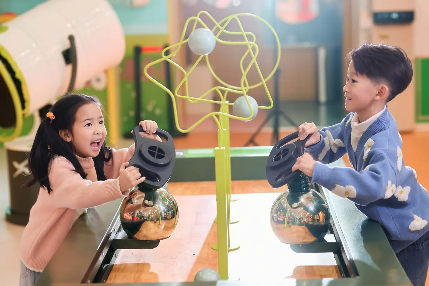 Two children exploring an interactive air-powered science exhibit at XPLOPLO Two children exploring an interactive air-powered science exhibit at XPLOPLO